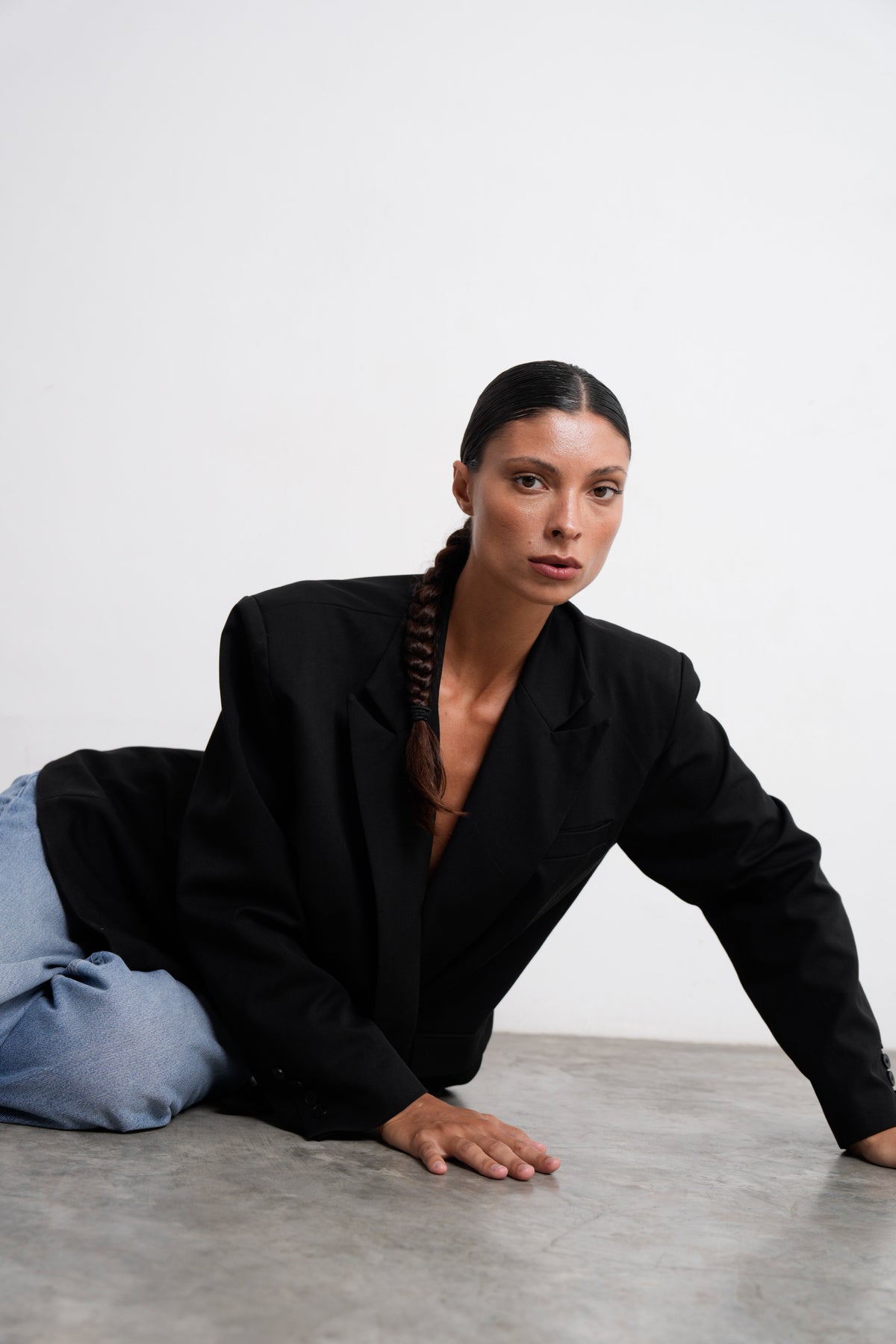 Große Frau im oversized schwarzen Tall Blazer über hellblauer Jeans